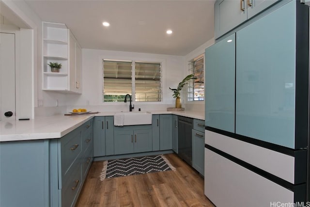 kitchen featuring dishwasher, white refrigerator, light hardwood / wood-style floors, and sink