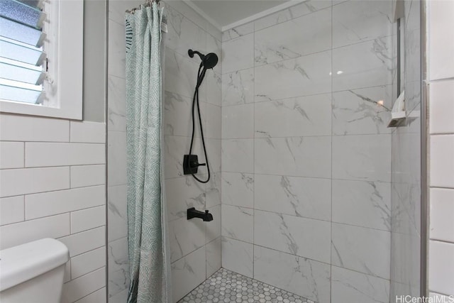 bathroom featuring curtained shower, toilet, and tile walls