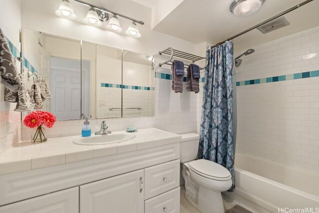 full bathroom featuring shower / bathtub combination with curtain, vanity, and toilet