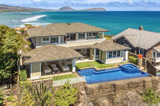 back of house featuring a patio area, a water and mountain view, and a pool with hot tub