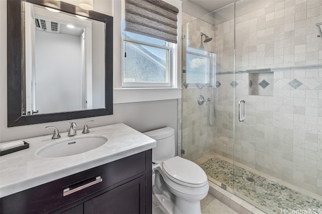 bathroom with tile patterned flooring, vanity, toilet, and a shower with door