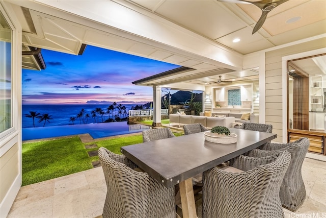 patio terrace at dusk with an outdoor living space and ceiling fan