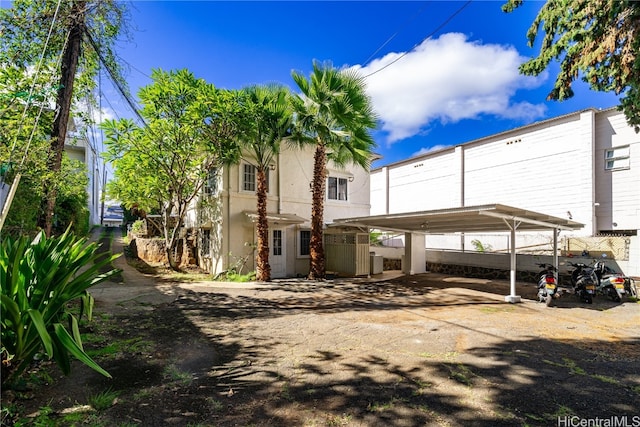 rear view of property with central air condition unit and a carport