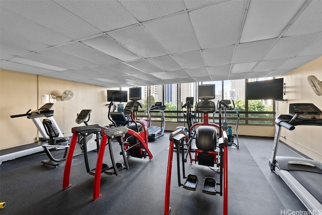 gym with a drop ceiling and a wealth of natural light