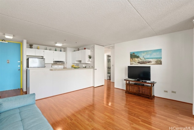 unfurnished living room featuring a textured ceiling and light hardwood / wood-style flooring