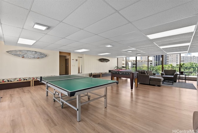 playroom with a drop ceiling and wood-type flooring