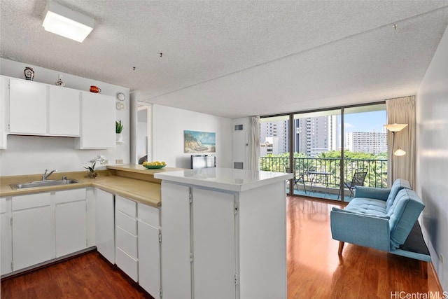 kitchen featuring kitchen peninsula, white cabinets, and a textured ceiling