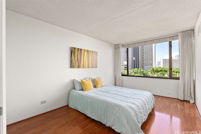 bedroom with hardwood / wood-style flooring and a textured ceiling