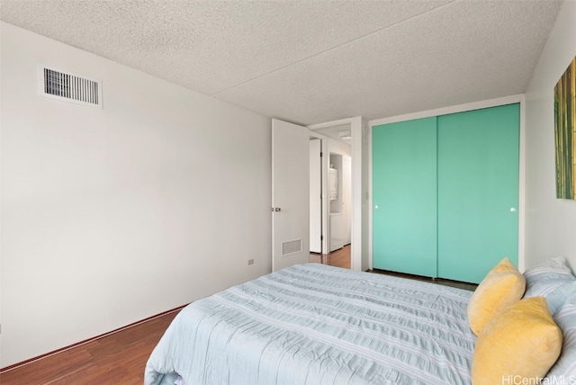 bedroom featuring wood-type flooring, a textured ceiling, and a closet