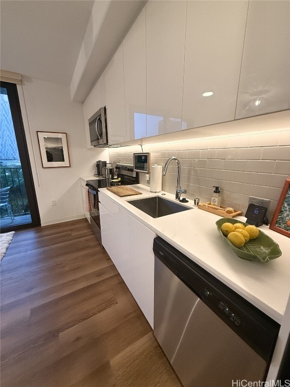 kitchen featuring white cabinetry, sink, appliances with stainless steel finishes, and dark wood-type flooring