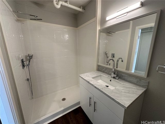 bathroom featuring a tile shower, vanity, and hardwood / wood-style flooring