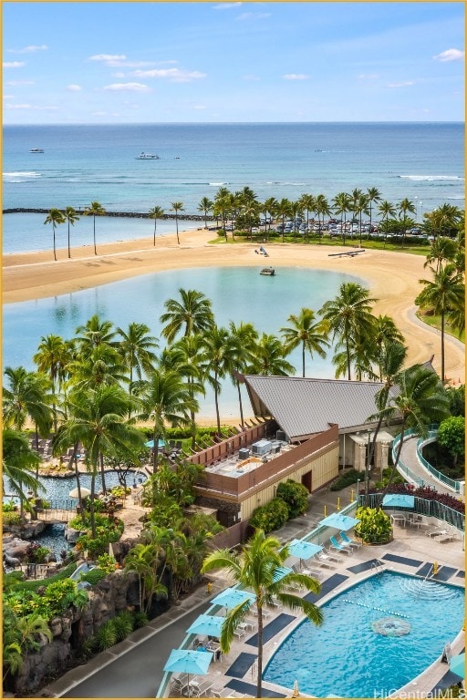 view of swimming pool featuring a water view and a beach view