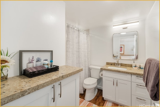 bathroom with toilet, vanity, and hardwood / wood-style flooring