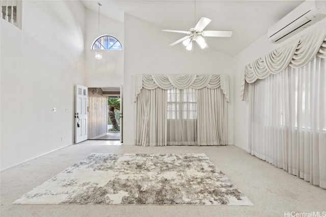 carpeted foyer featuring high vaulted ceiling, a wall unit AC, and ceiling fan