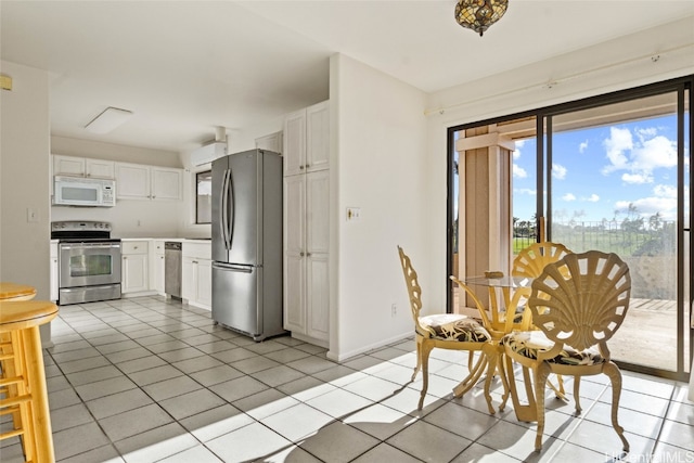 kitchen with light tile patterned flooring, white cabinetry, and appliances with stainless steel finishes