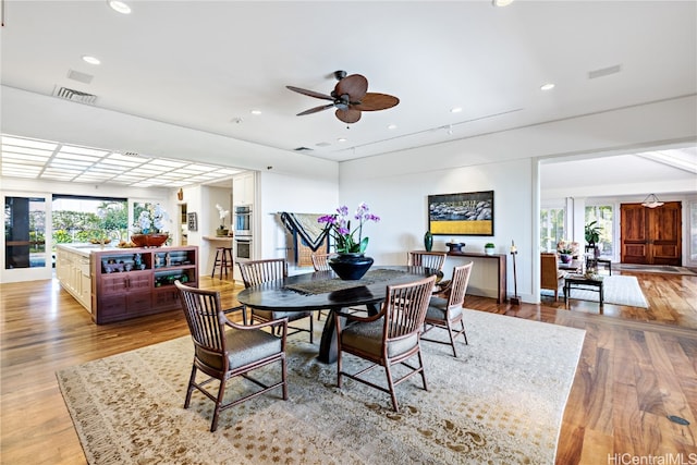 dining room featuring ceiling fan, light wood-type flooring, and a wealth of natural light