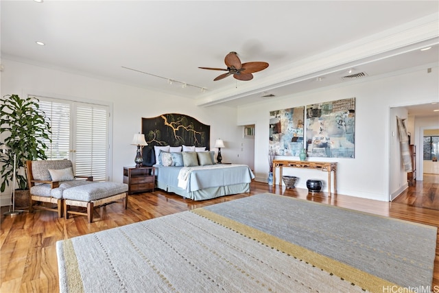 bedroom with wood-type flooring, track lighting, and ceiling fan