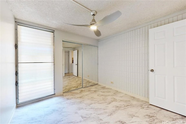 unfurnished room featuring ceiling fan and a textured ceiling