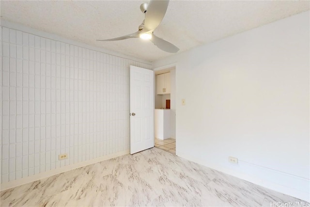 empty room featuring a textured ceiling and ceiling fan