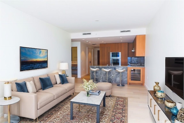 living room with light wood-type flooring and beverage cooler