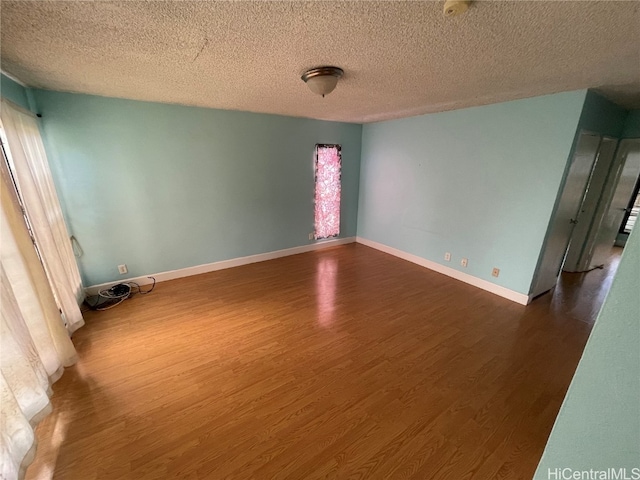 spare room with dark hardwood / wood-style flooring and a textured ceiling