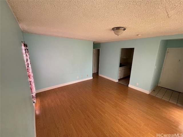 unfurnished room featuring hardwood / wood-style floors and a textured ceiling