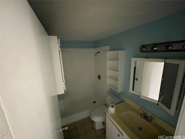 bathroom featuring toilet, a shower, vanity, and tile patterned floors