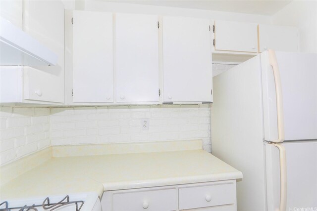 87-118 Helelua St Unit B101, Waianae, HI 96792 - kitchen featuring freestanding refrigerator, light countertops, white cabinets, and tasteful backsplash