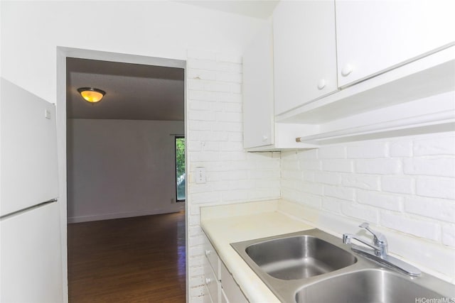 87-118 Helelua St Unit B101, Waianae, HI 96792 - kitchen with freestanding refrigerator, light countertops, white cabinetry, and a sink