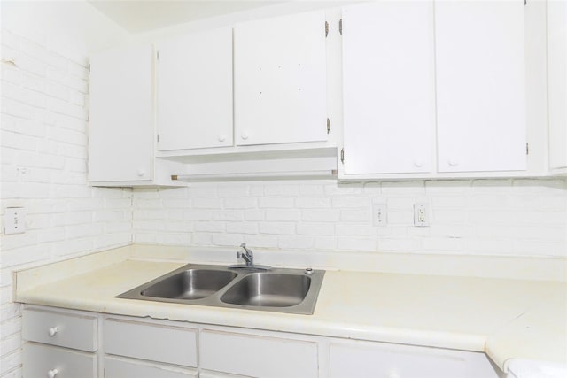 87-118 Helelua St Unit B101, Waianae, HI 96792 - kitchen featuring backsplash, light countertops, white cabinetry, and a sink