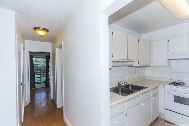 87-118 Helelua St Unit B101, Waianae, HI 96792 - kitchen featuring a sink, tasteful backsplash, white cabinetry, light countertops, and white range with gas stovetop
