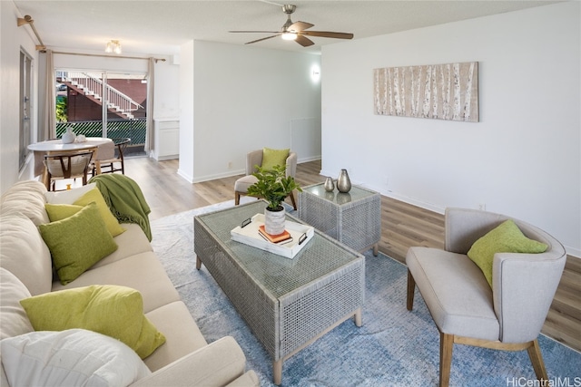 living room featuring ceiling fan and light hardwood / wood-style floors