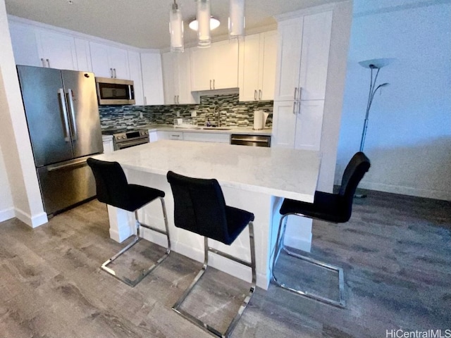 kitchen with pendant lighting, white cabinetry, and stainless steel appliances