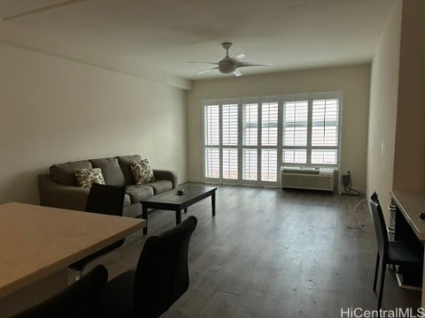 living room featuring ceiling fan and dark hardwood / wood-style flooring