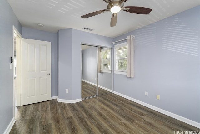 unfurnished bedroom featuring ceiling fan, dark hardwood / wood-style flooring, and a closet