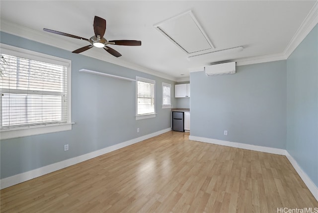 unfurnished living room with crown molding, a wall unit AC, ceiling fan, and light wood-type flooring