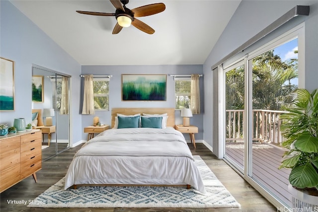 bedroom with hardwood / wood-style flooring, vaulted ceiling, multiple windows, and access to outside