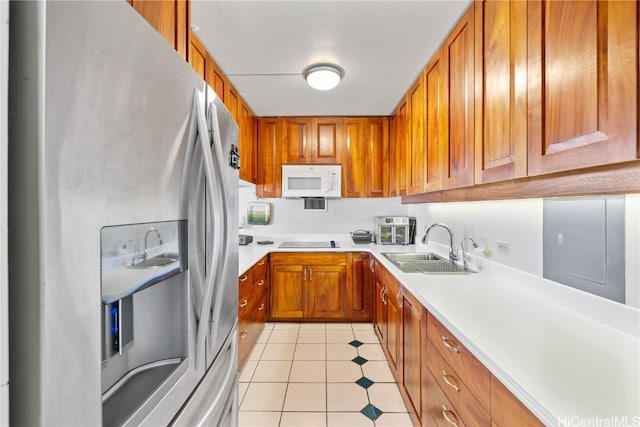 kitchen featuring stainless steel fridge with ice dispenser, cooktop, light tile patterned floors, and sink