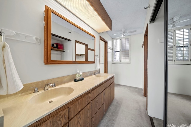 bathroom featuring ceiling fan, a textured ceiling, and vanity