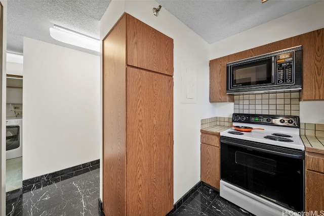 kitchen featuring black microwave, electric range, washer / clothes dryer, and a textured ceiling