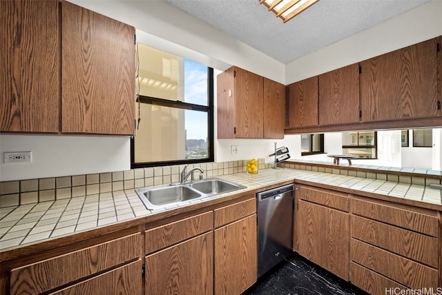 kitchen featuring tile counters, dishwasher, a textured ceiling, and sink