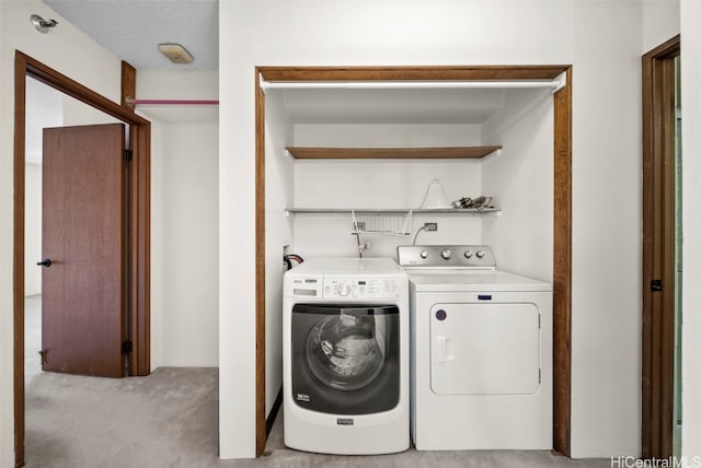 laundry area featuring light colored carpet, independent washer and dryer, and a textured ceiling