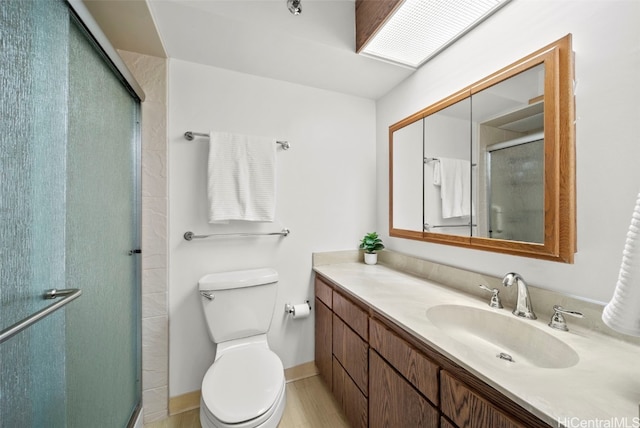 bathroom featuring vanity, an enclosed shower, and toilet