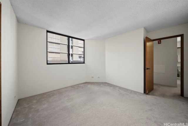 unfurnished room featuring light colored carpet and a textured ceiling