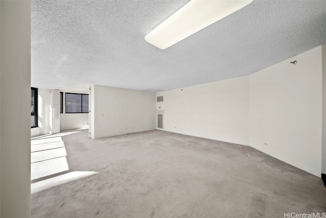 unfurnished living room with light carpet and a textured ceiling