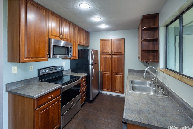 kitchen with a textured ceiling, dark hardwood / wood-style floors, sink, and appliances with stainless steel finishes