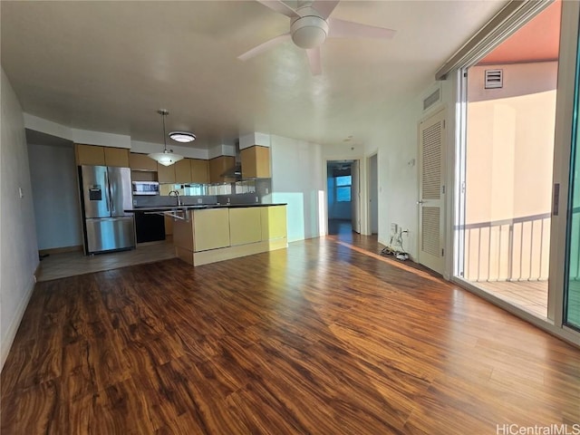 kitchen featuring hardwood / wood-style floors, wall chimney range hood, sink, ceiling fan, and appliances with stainless steel finishes