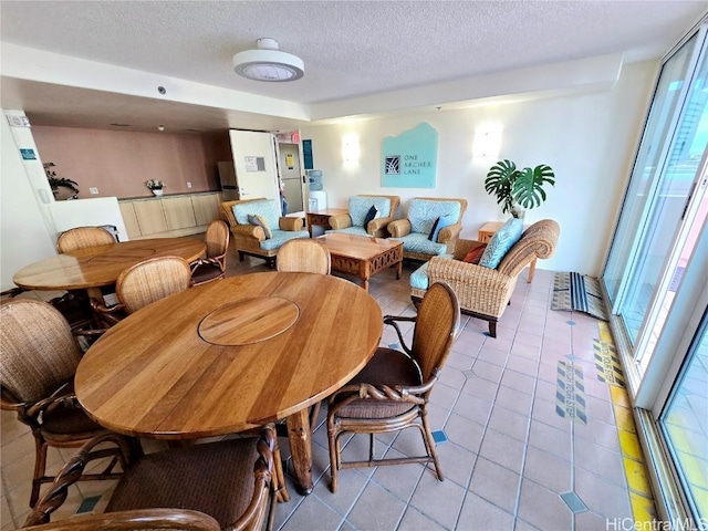 dining room with plenty of natural light, light tile patterned flooring, and a textured ceiling