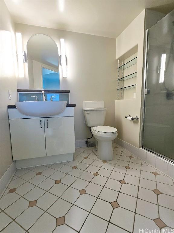 bathroom with an enclosed shower, vanity, toilet, and tile patterned flooring