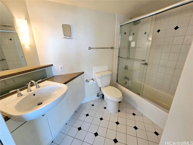 full bathroom featuring shower / bath combination with glass door, sink, tile patterned flooring, and toilet